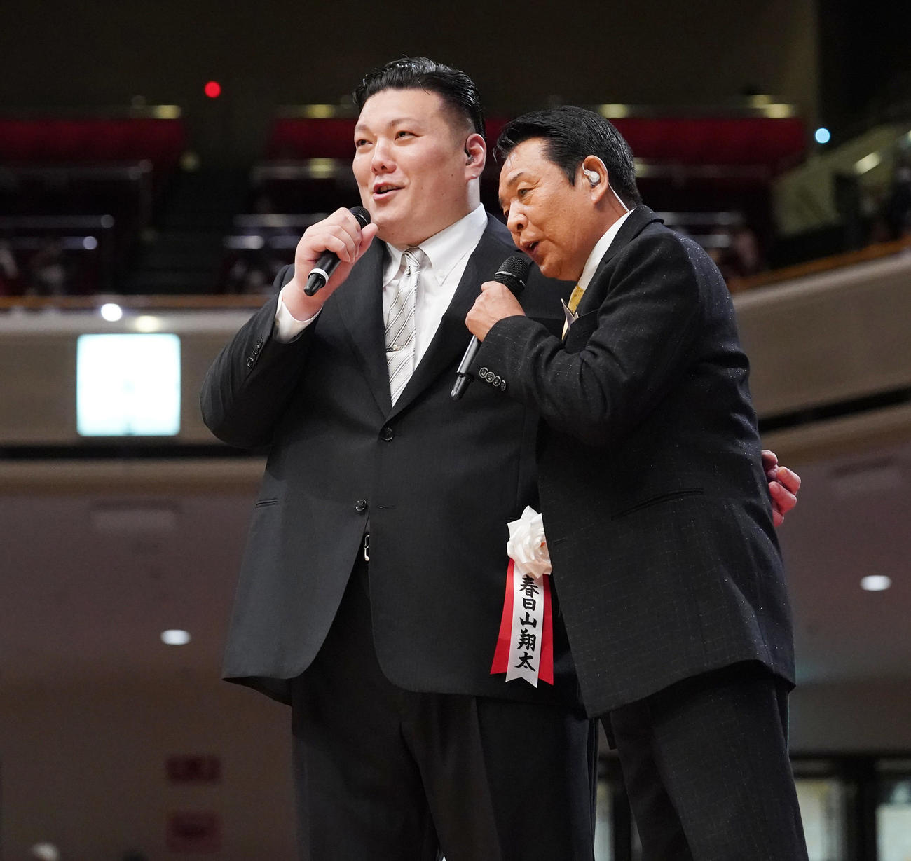 断髪式後のあいさつを終えた春日山親方（元関脇勢）はスペシャルゲストで歌手の山本譲二（右）と土俵脇に設けられたステージで熱唱する（2023年6月撮影）