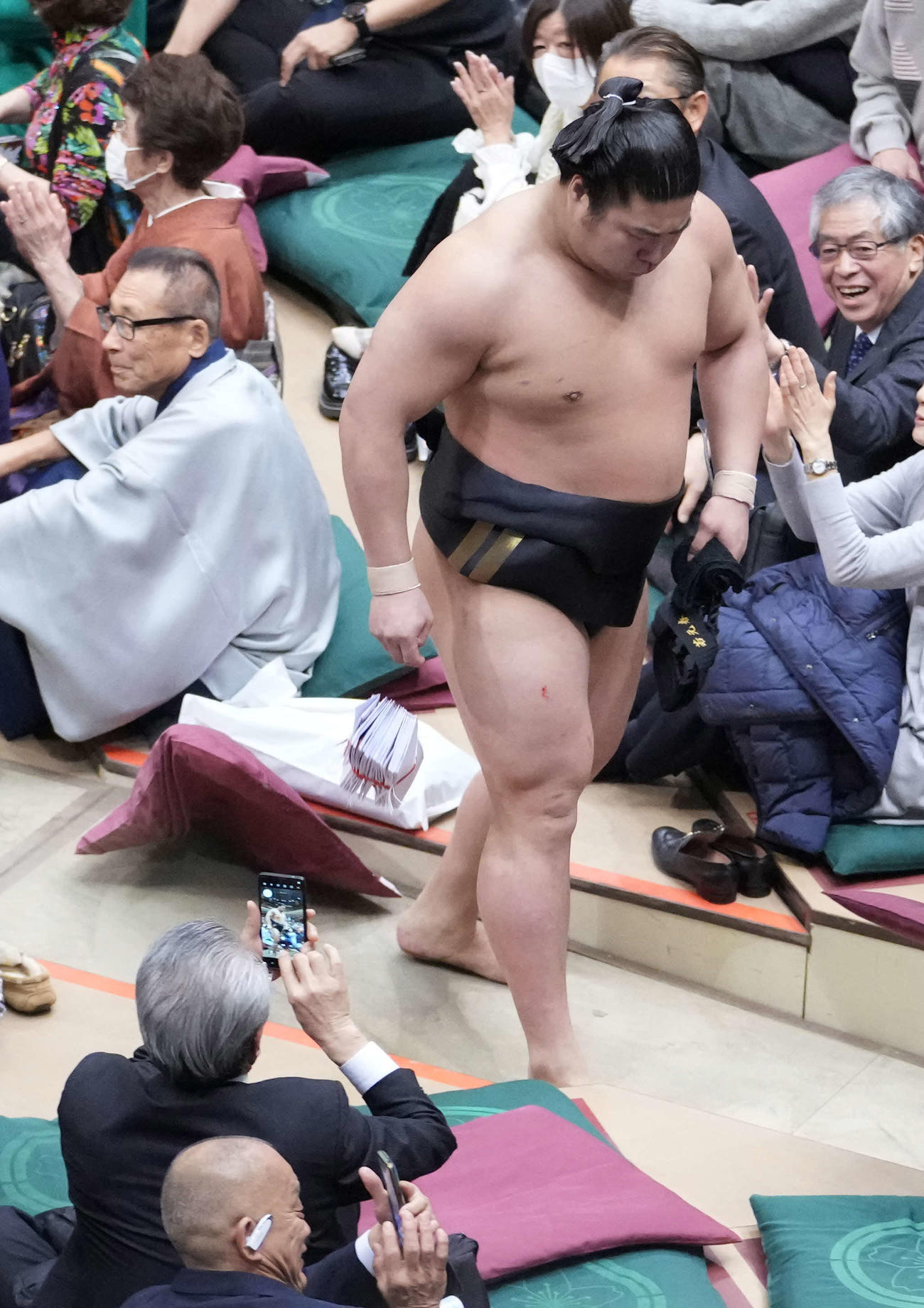 照ノ富士を破った若元春は場内を舞った座布団が右手を直撃し懸賞金の束がこぼれ落ちる（撮影・小沢裕）