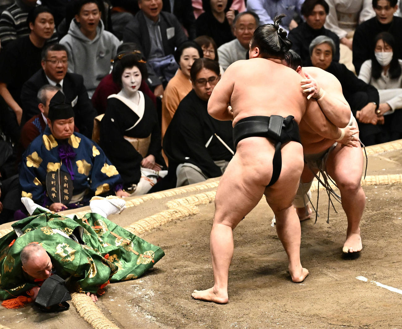 霧島（中央）と北勝富士（右）の取り組みで転倒する行司木村容堂（撮影・滝沢徹郎）