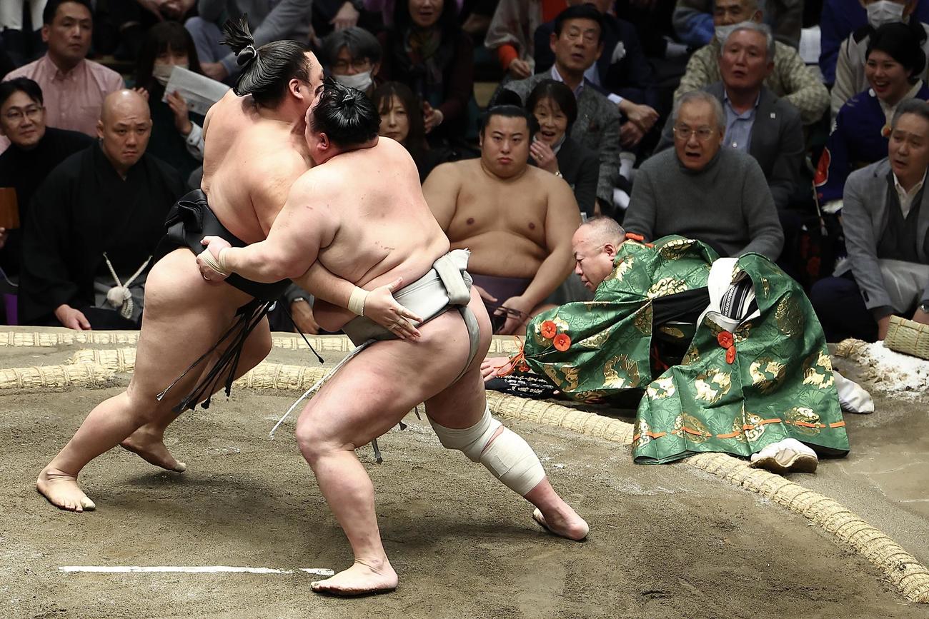 霧島（左）北勝富士の取り組みで、つまずき転倒する行司の木村容堂（右）（撮影・河田真司）