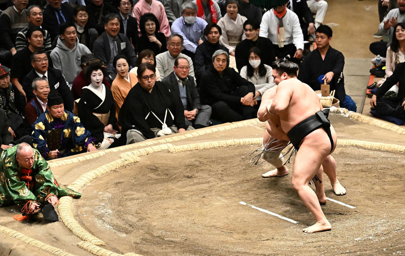 霧島と北勝富士の取り組みで転倒する行司木村容堂（左）（撮影・滝沢徹郎）