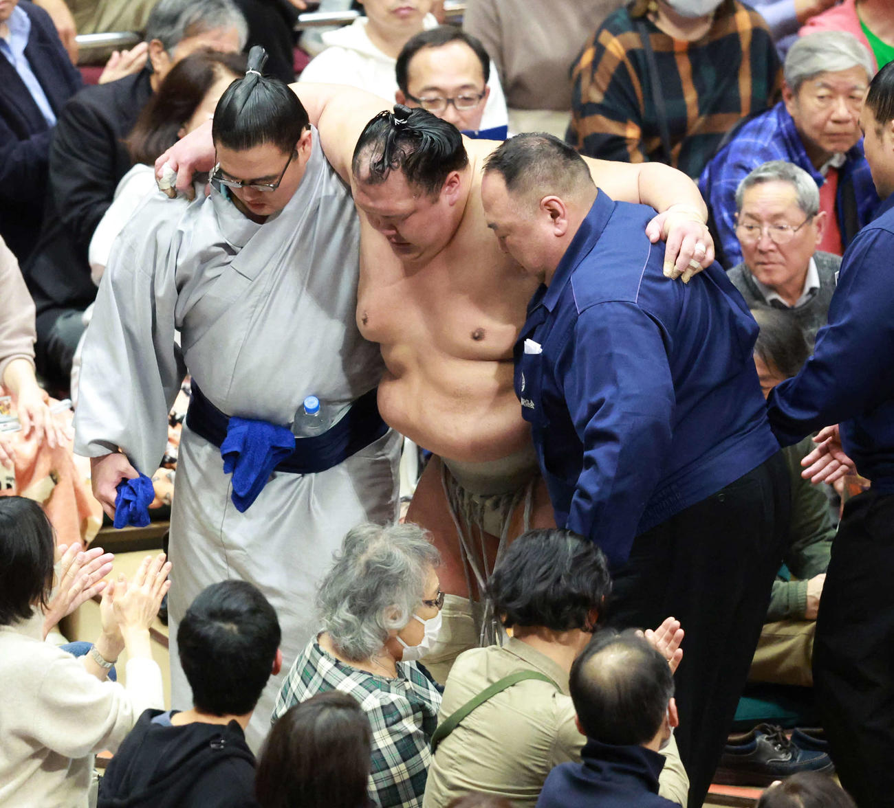 初場所8日目　豊昇龍に敗れた際にひざを負傷した北勝富士（中央）は両脇を支えられて引き揚げる（2024年1月21日撮影）