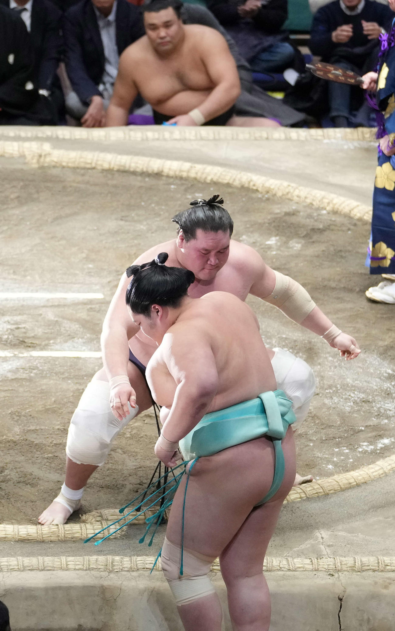 照ノ富士は琴ノ若（手前）を寄り切りで破る。後方奥は土俵控えの霧島（撮影・小沢裕）