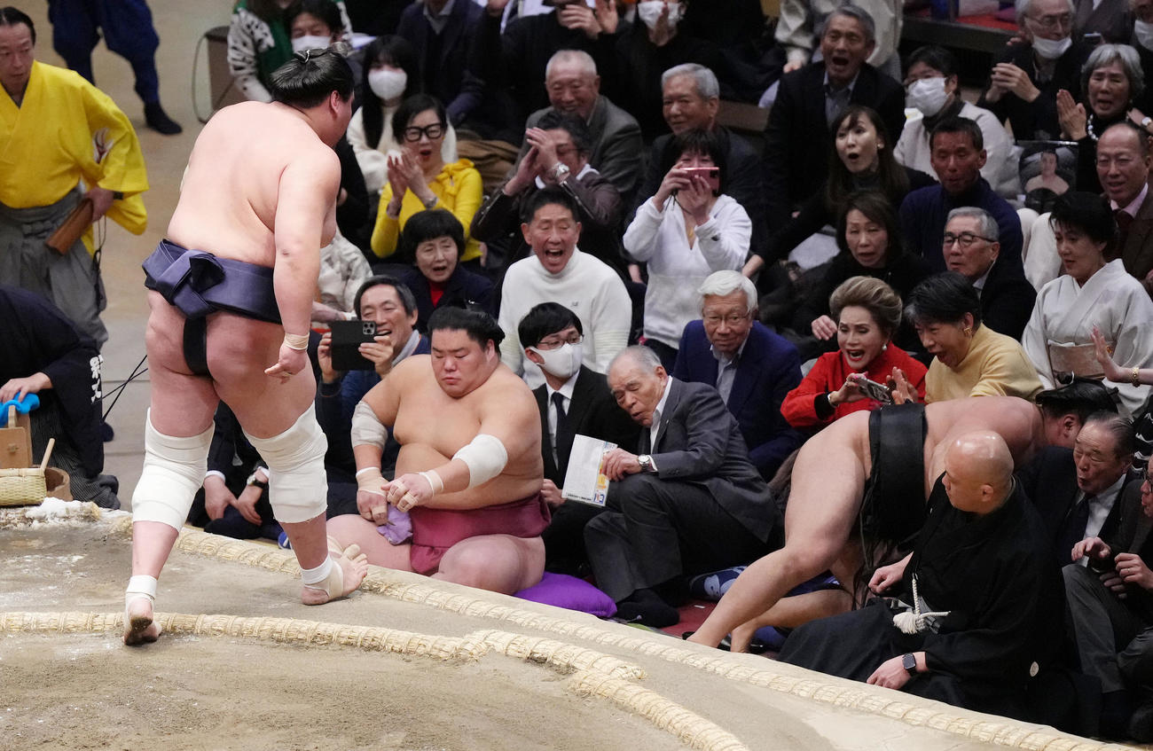 照ノ富士の寄り切りで土俵から落ちてきた霧島（右端）に驚くデヴィ夫人（右から3人目）（撮影・菅敏）