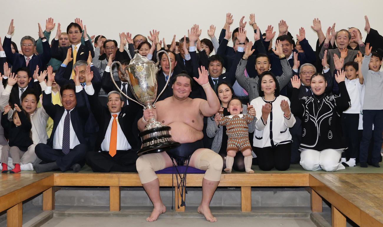 大相撲初場所で優勝し、賜杯を手に笑顔を見せる照ノ富士（中央）。その右は愛息の照務甚（てむじん）君と妻のドルジハンドさん（代表撮影）