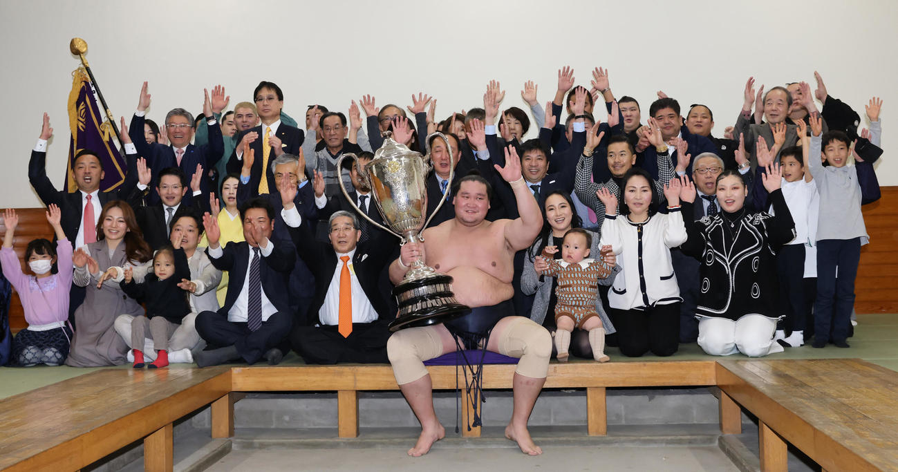 大相撲初場所で優勝し、賜杯を手に笑顔を見せる照ノ富士（中央）。その右は愛息の照務甚（てむじん）君と妻のドルジハンドさん（代表撮影）