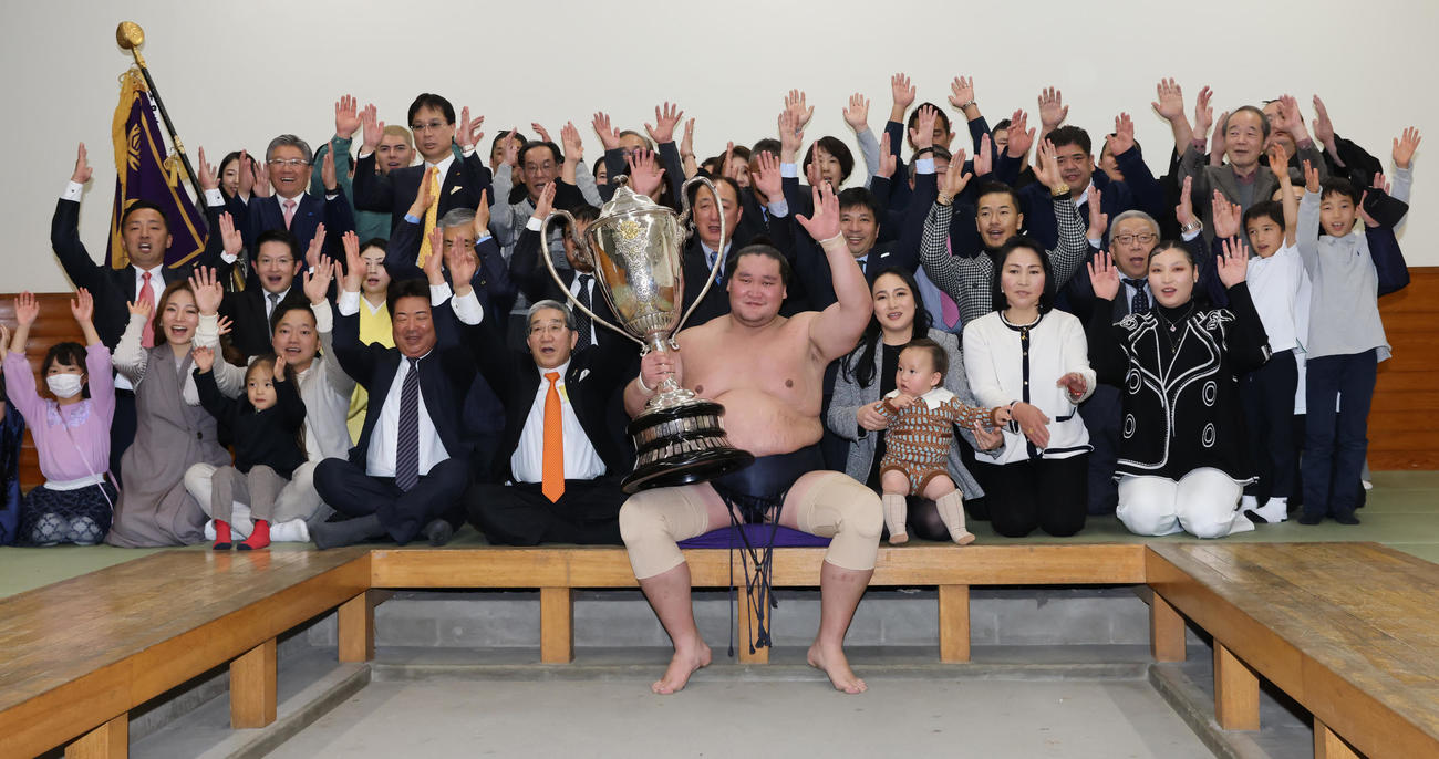 大相撲初場所で優勝し、賜杯を手に笑顔を見せる照ノ富士（中央）。その右は愛息の照務甚（てむじん）君と妻のドルジハンドさん（代表撮影）
