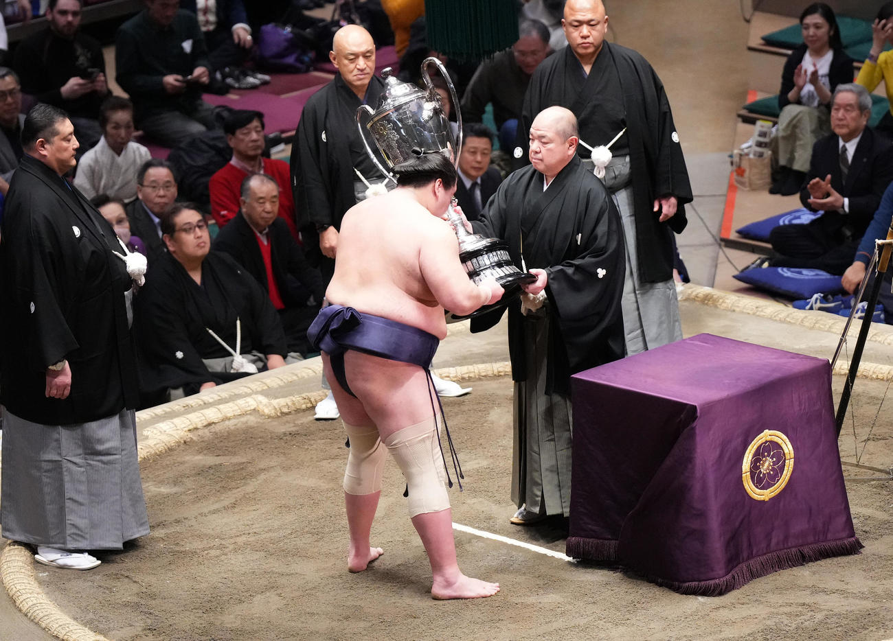 優勝し、八角理事長（右）から賜杯を受け取る照ノ富士。左橋は佐渡ケ嶽親方（撮影・菅敏）