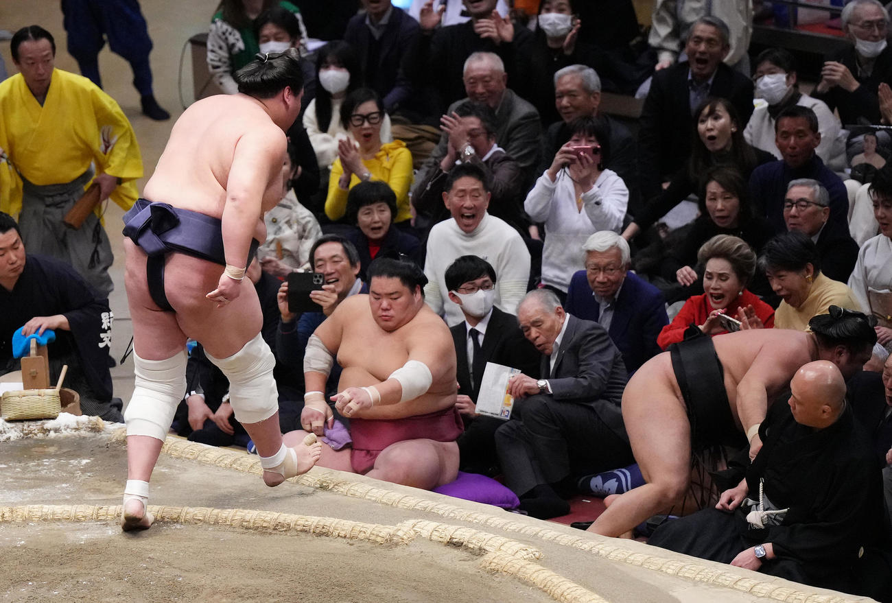 照ノ富士に寄り切りで土俵から落ちてきた霧島（右から2人目）に驚くデヴィ夫人（右から3人目）（撮影・菅敏）