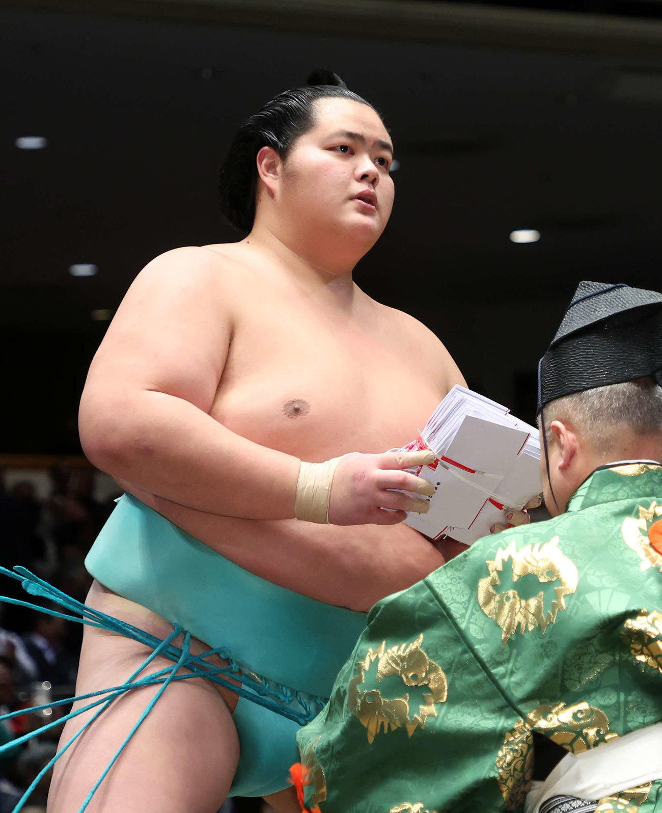 懸賞金の束を手に土俵を引き揚げる琴ノ若（撮影・鈴木正人）