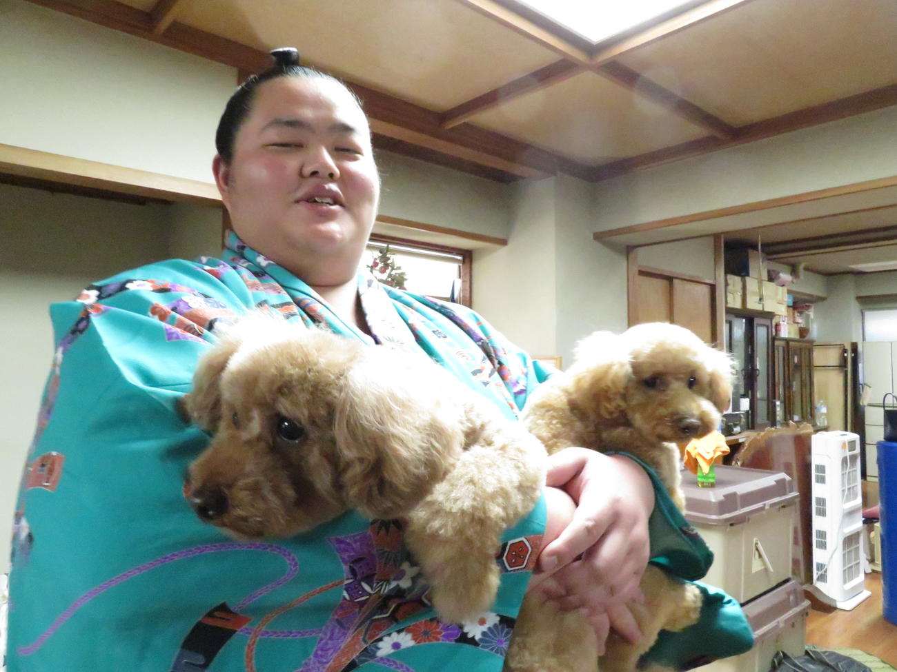 会見後、師匠の佐渡ケ嶽親方の愛犬チェリー（右）と桜子（左）を抱きかかえ、笑顔を見せる琴ノ若