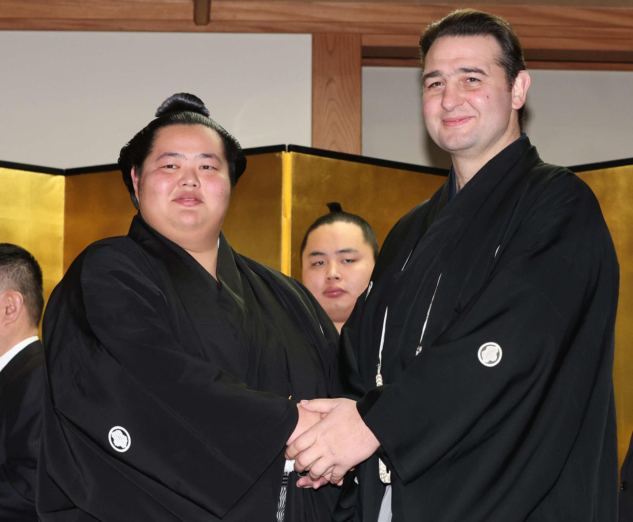 大関昇進伝達式の使者として訪れた鳴門審判委員（右）と握手をする琴ノ若（代表撮影）