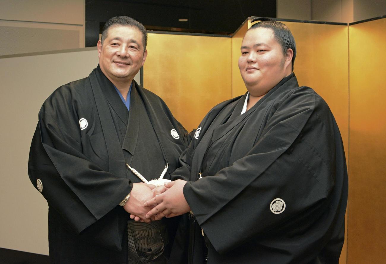 佐渡ケ嶽部屋の祝賀会で、父で師匠の佐渡ケ嶽親方（左）と握手する琴ノ若（共同）