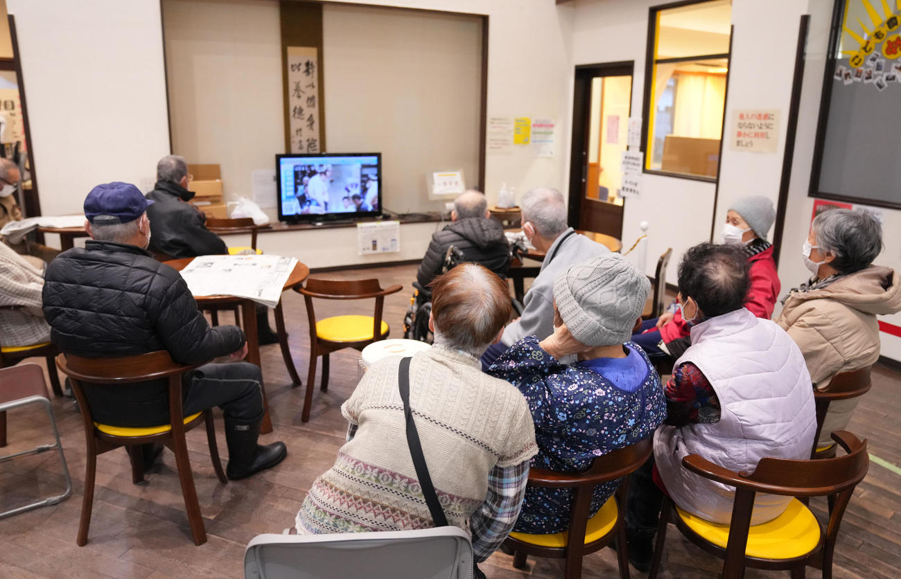 能登半島地震で設置された石川県穴水町の避難所で、地元出身力士の遠藤が出場した初場所の中継に見入る町民ら＝2024年1月17日