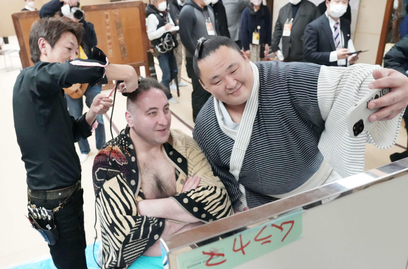 断髪式後に栃ノ心の整髪をのぞきに来た玉鷲（右）はスマホを手に栃ノ心と自撮りする（撮影・小沢裕）