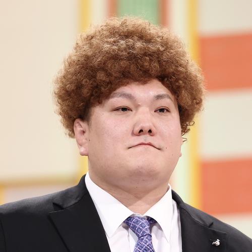 ステージでカツラを被る春日山親方（撮影・河田真司）
