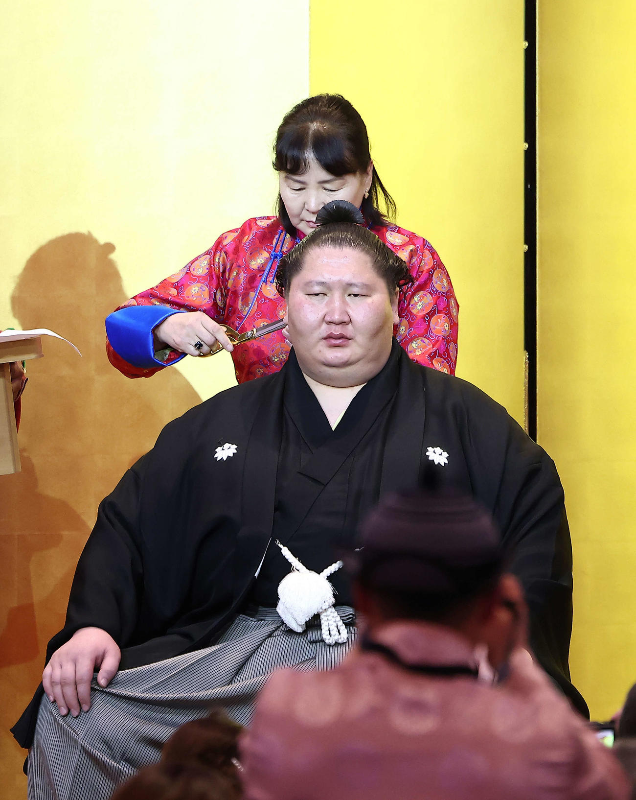 母のボロル・トーヤさんにはさみを入れてもらう逸ノ城（撮影・河田真司）