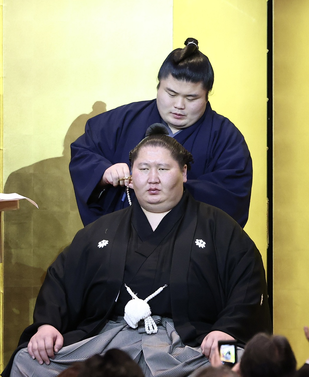 貴健斗（後方）にはさみを入れてもらう逸ノ城（撮影・河田真司）