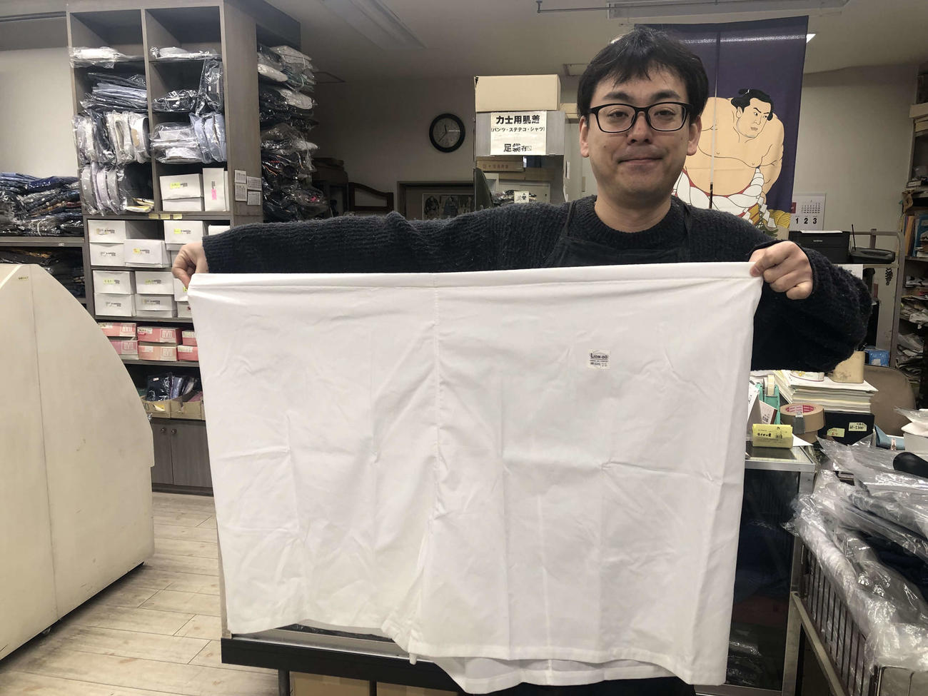 ライオン堂で販売されている力士用のパンツを持つ4代目店主の久保田純平さん（撮影・平山連）