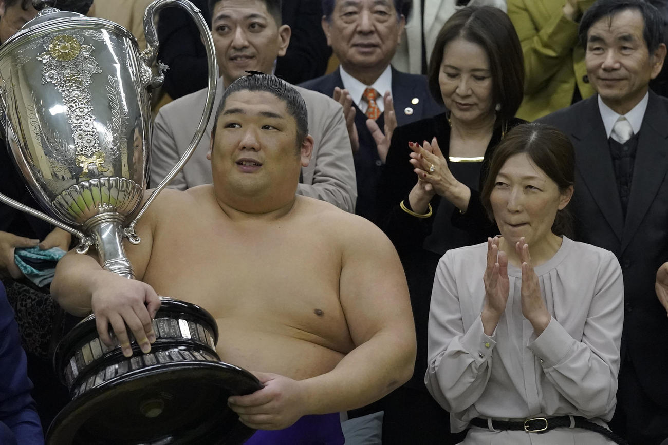 賜杯を手にし、母・石岡桃子さん（右）から拍手される尊富士