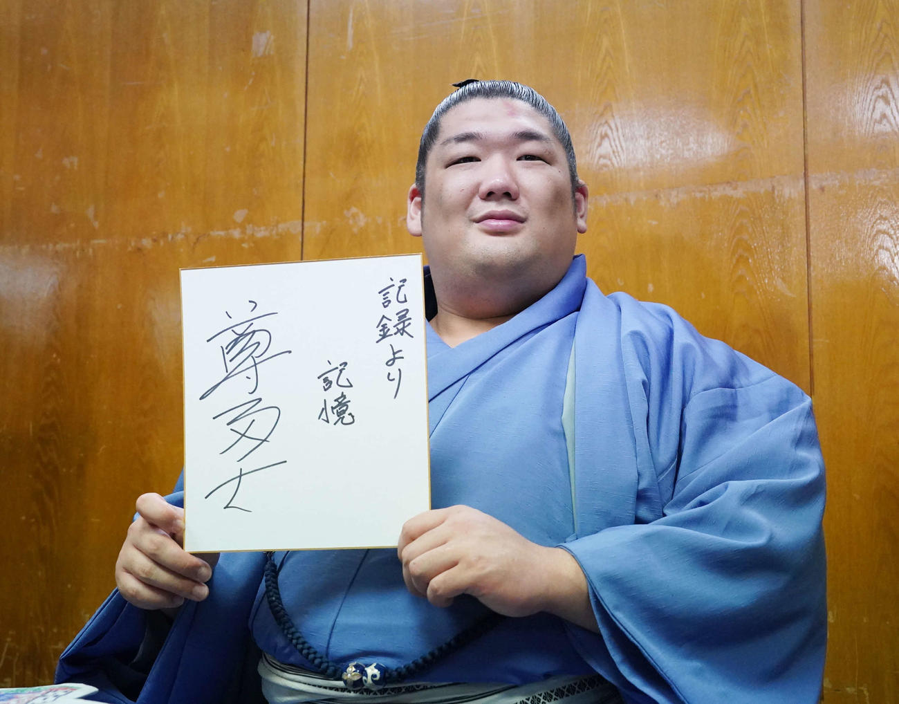 優勝一夜明け会見で「記録より記憶」としたためた色紙を手にする尊富士（撮影・小沢裕）