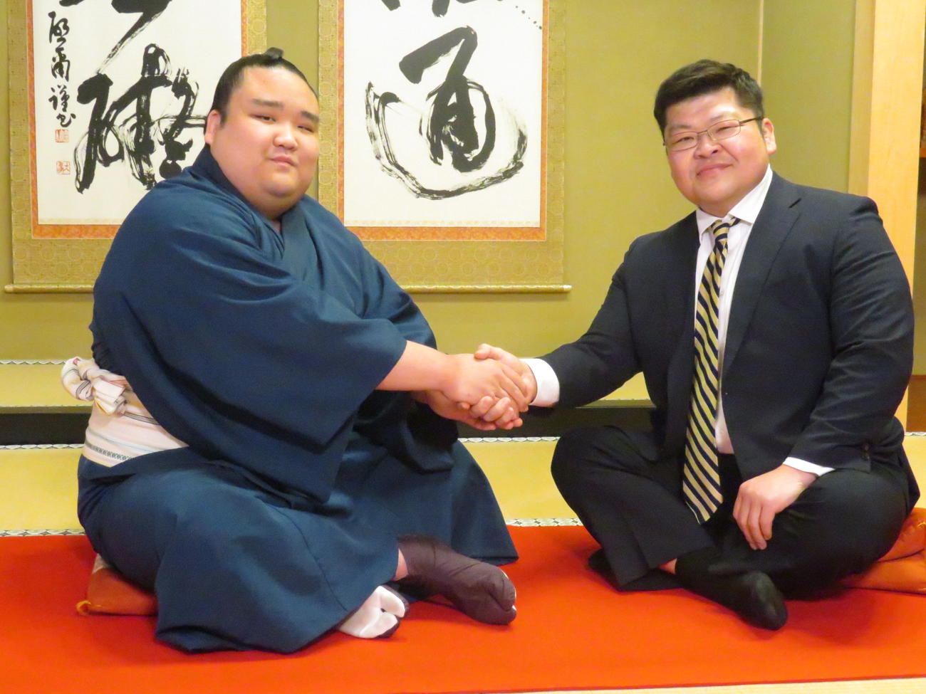 新十両昇進が決まり、師匠の押尾川親方（右）と握手を交わす風賢央
