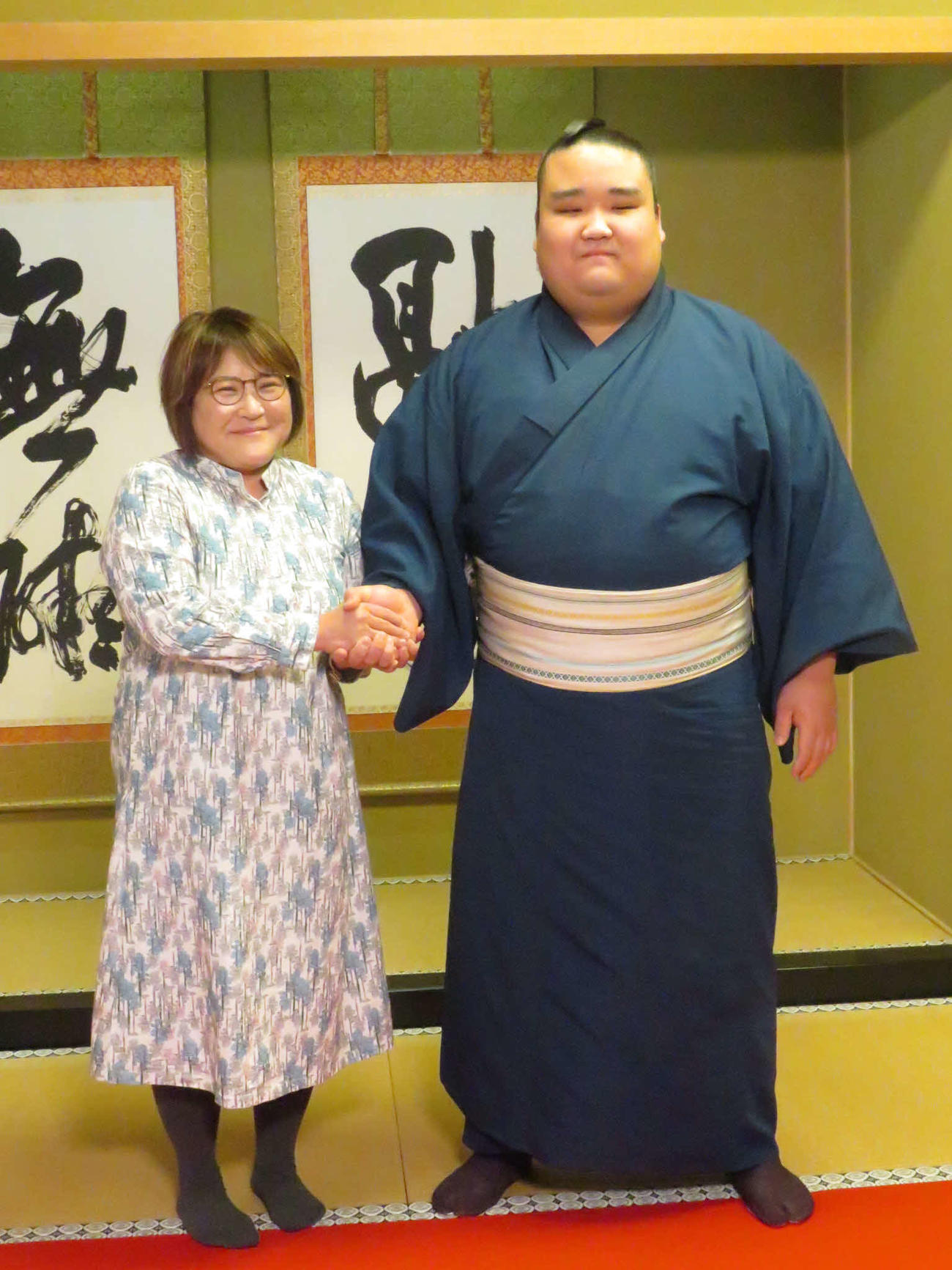 新十両昇進が決まり、母るみさん（左）と握手を交わす風賢央