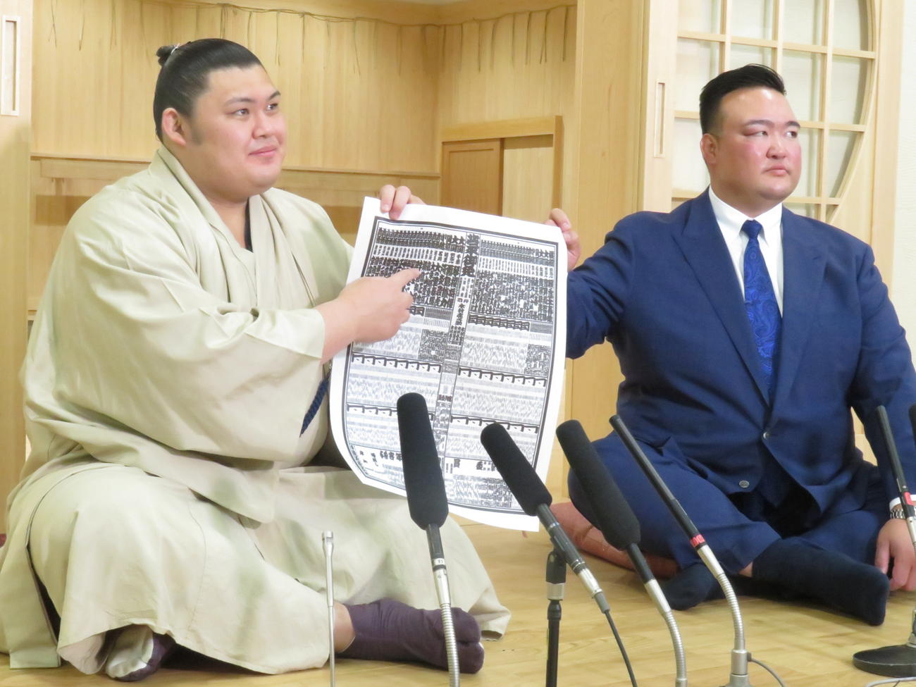 ちょんまげ姿で新三役会見に臨んだ大の里。右は師匠の二所ノ関親方