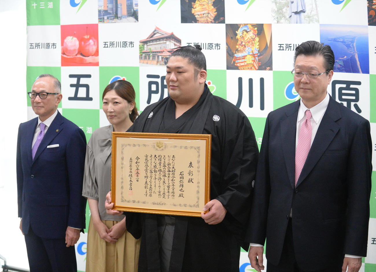 3月の大相撲春場所で110年ぶりの新入幕優勝を成し遂げた尊富士（右から2人目）は青森県五所川原市から市民栄誉賞を授与された。右から伊勢ケ浜親方、1人おいて母の石岡桃子さん、佐々木孝昌市長（撮影・濱本神威）