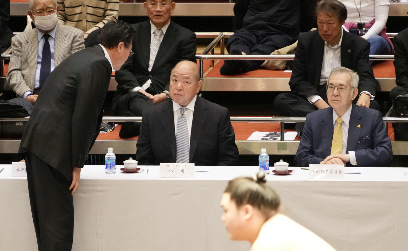 横審稽古総見で八角理事長（中央）に何事か報告する伊勢ケ浜親方。右は横綱審議委員会の山内委員長（撮影・小沢裕）