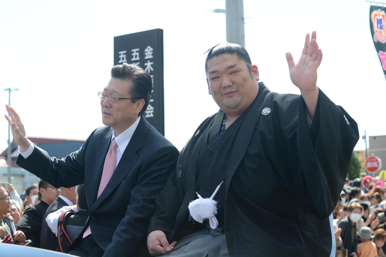 1日、地元金木町の金木総合支所を出発する尊富士（右）。左は伊勢ケ浜親方