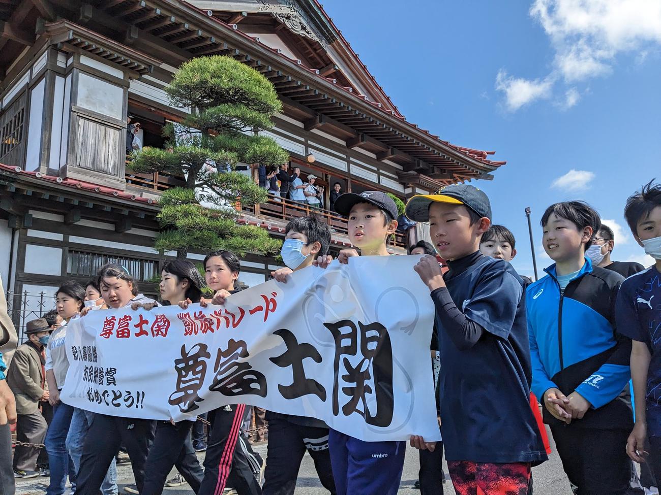 地域の子どもたちが尊富士を先導する（撮影・濱本神威）