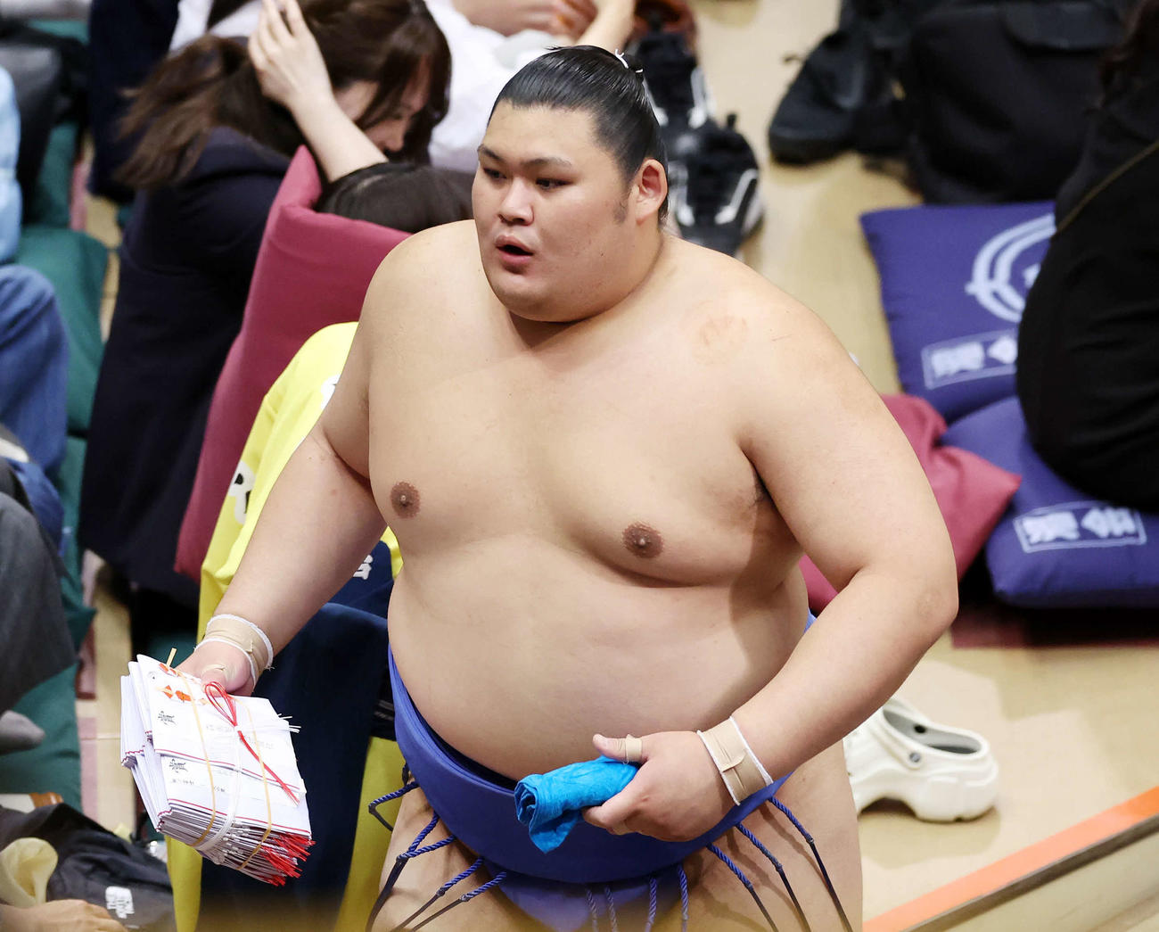 懸賞金の束を手に土俵を引き揚げる大の里（撮影・鈴木正人）