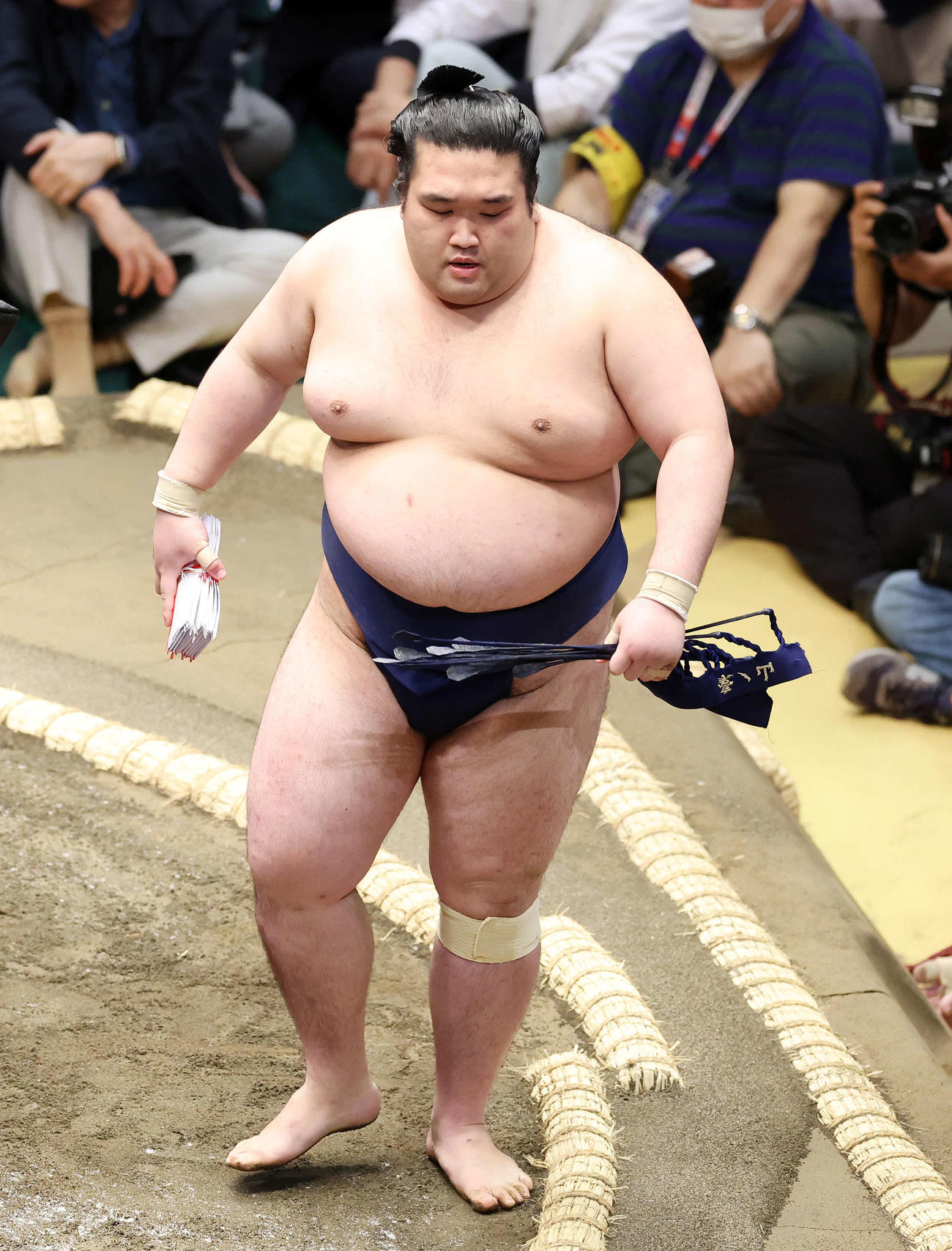 懸賞金の束を手に土俵を引き揚げる豪ノ山（撮影・鈴木正人）