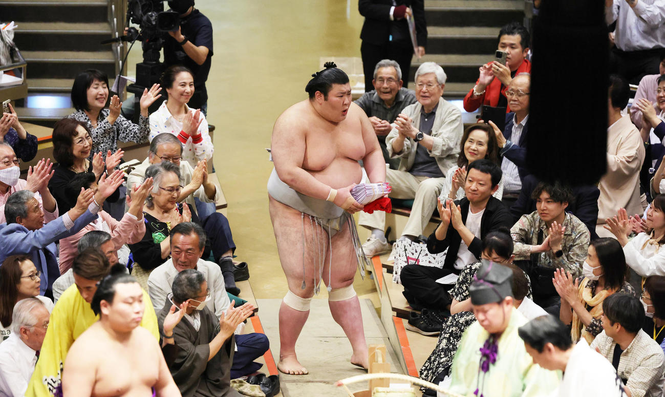 霧島を破り、懸賞金を手に花道を引き揚げる熱海富士（撮影・野上伸悟）