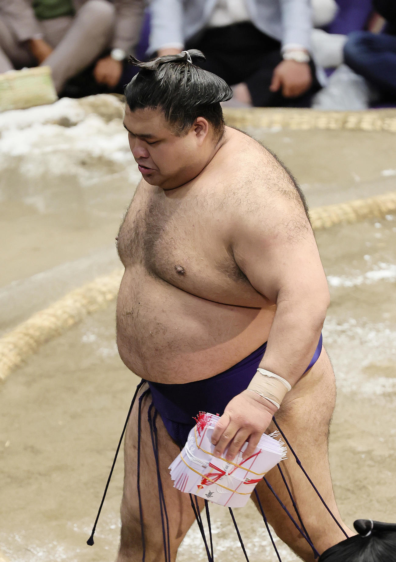 琴桜を上手投げで破り、懸賞の束を手に引き揚げる高安（撮影・足立雅史）
