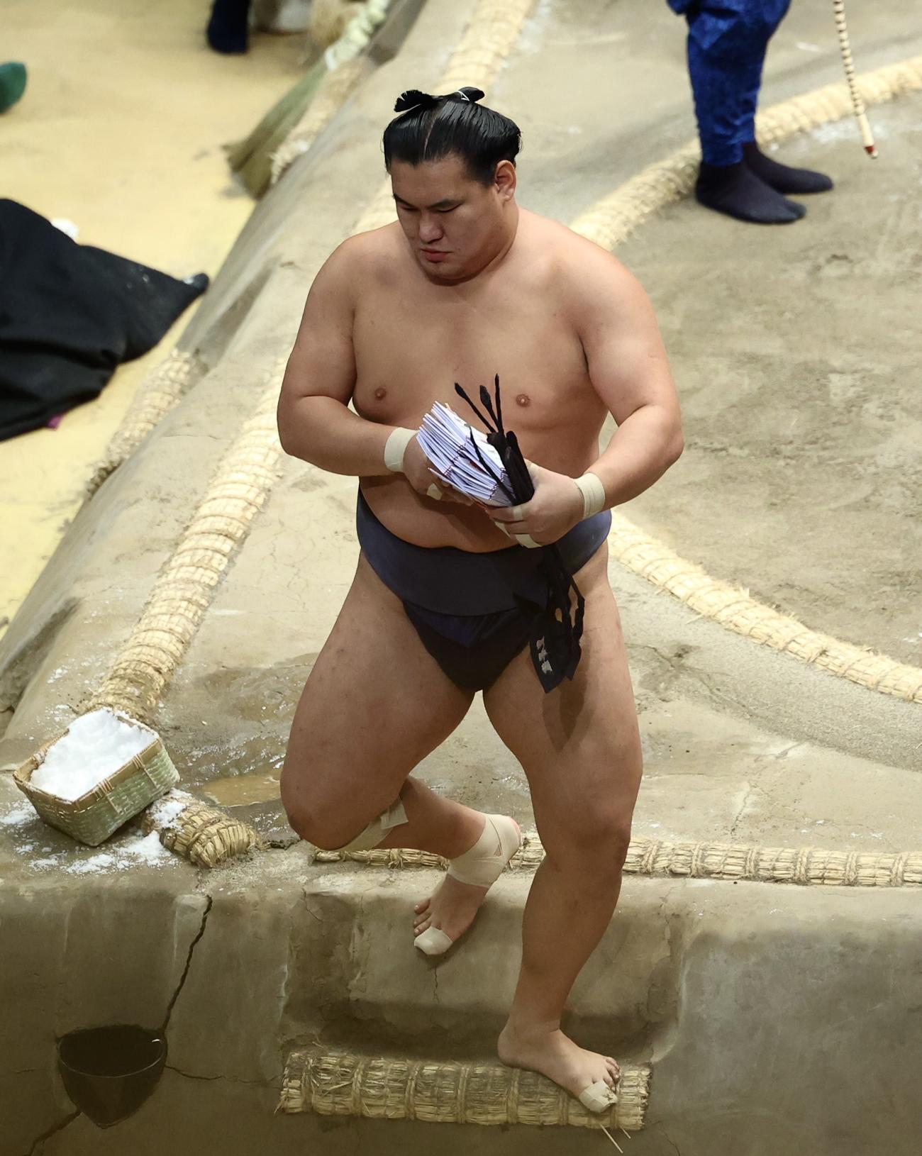 大の里を下手投げで破り、懸賞金の束を手に土俵から引き揚げる豊昇龍（撮影・河田真司）