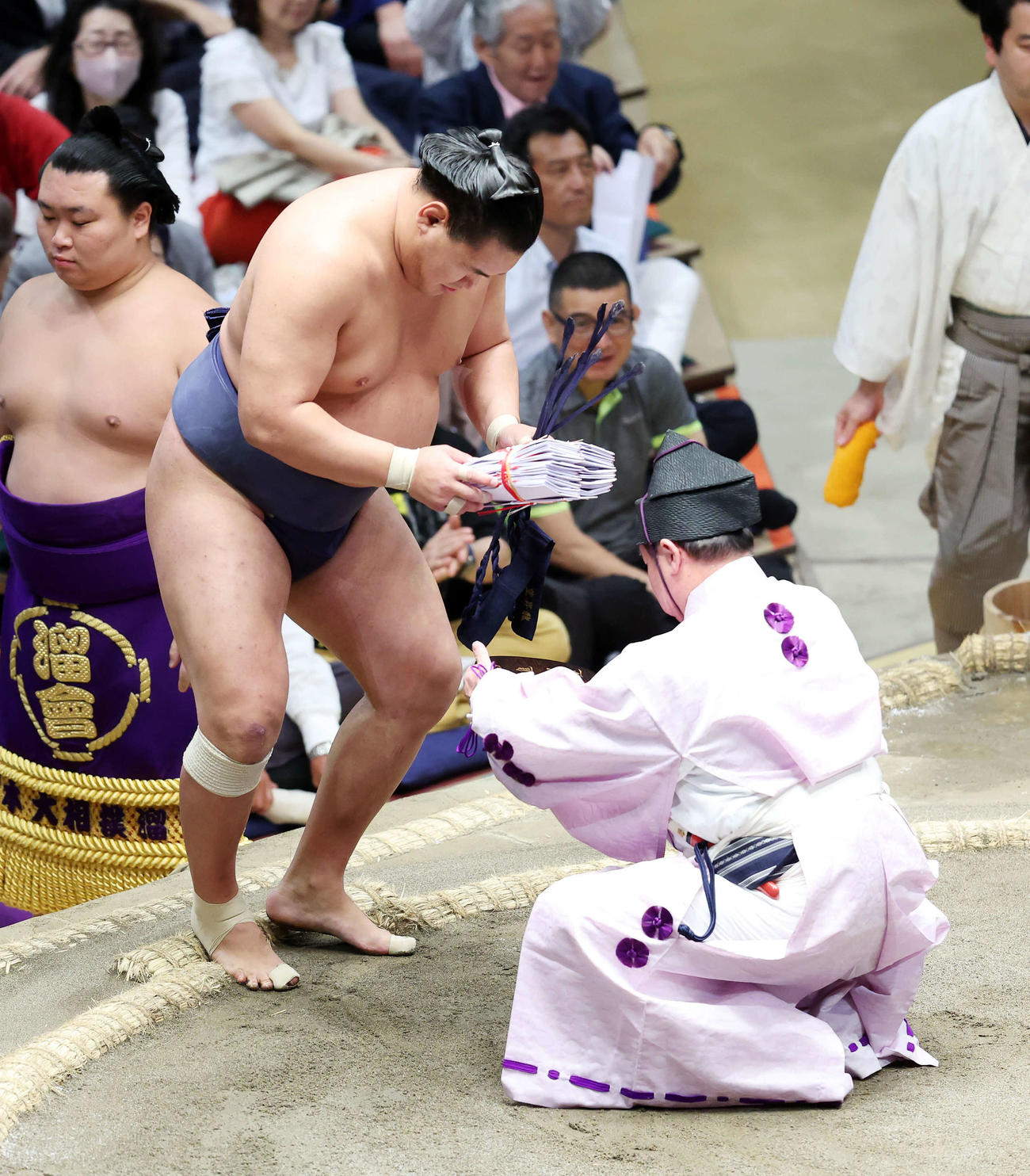 懸賞金の束を受け取る豊昇龍（撮影・鈴木正人）