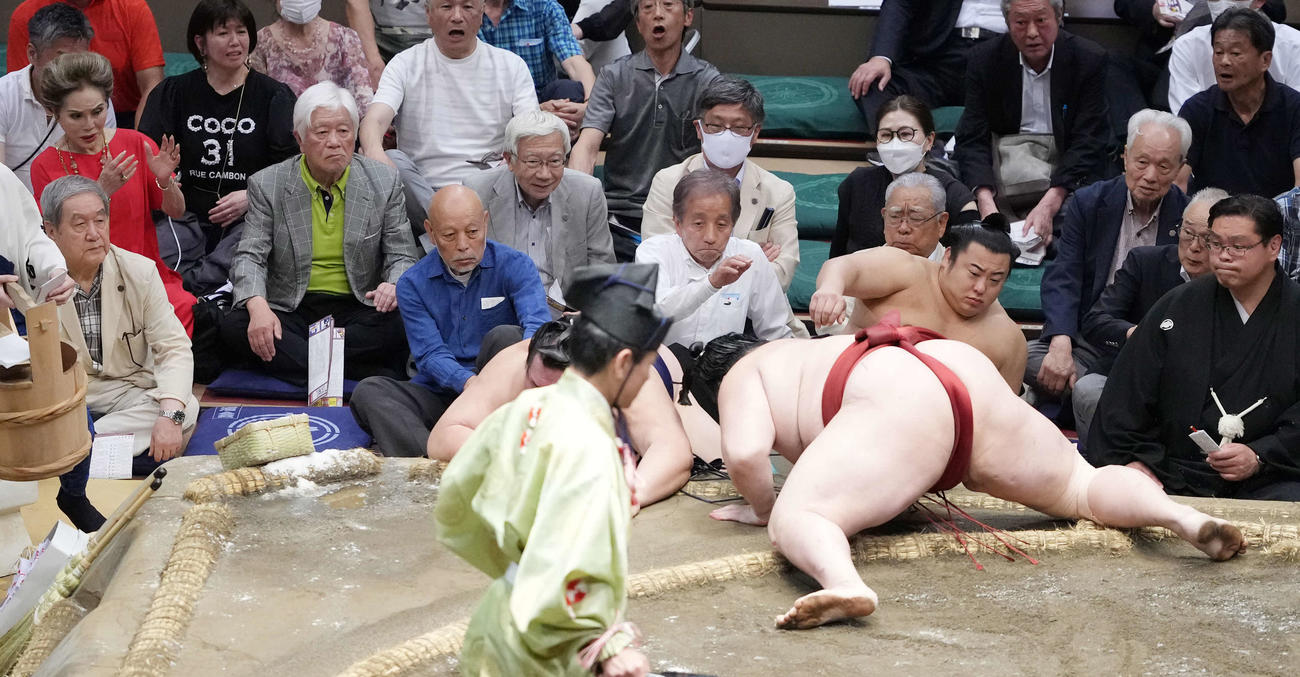 隆の勝（右）は友風を押し出しで破る。左端は観戦するデヴィ夫人（撮影・小沢裕）