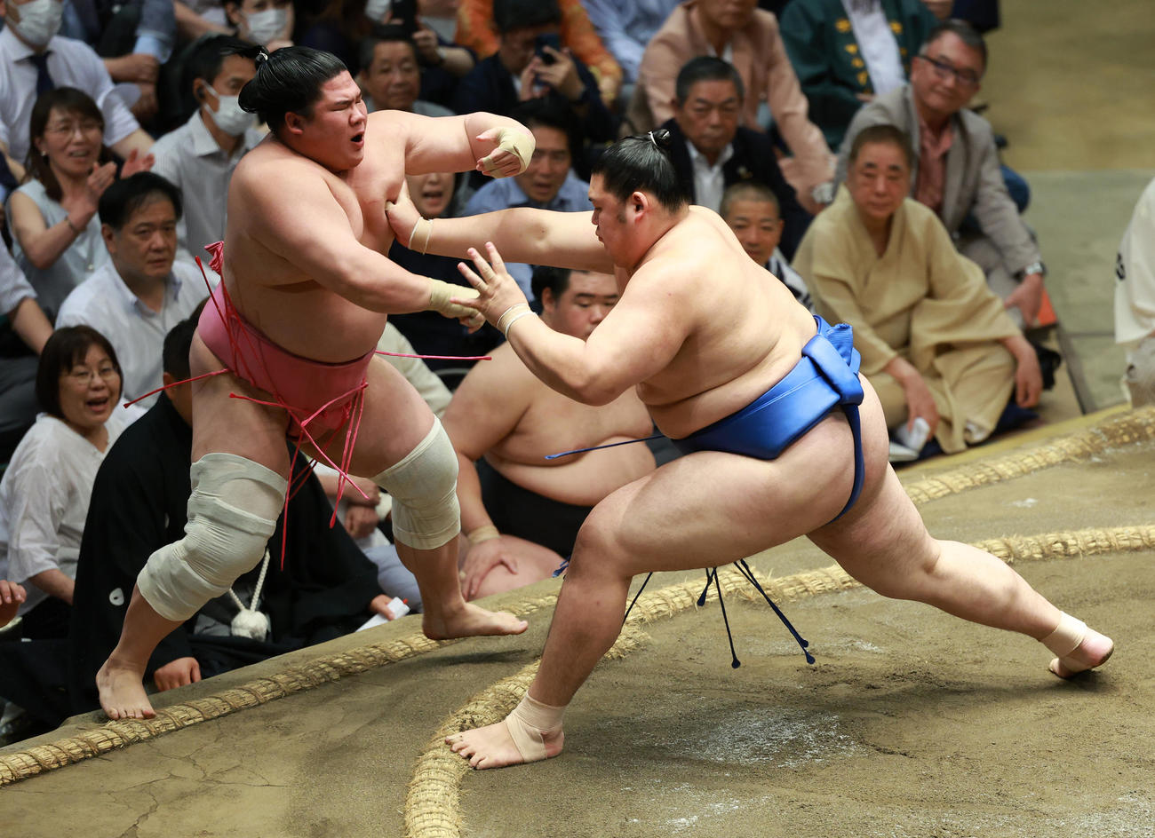 宇良（左）を押し出しで破る大の里。観戦する三遊亭好楽の姿も（後列右）（撮影・中島郁夫）