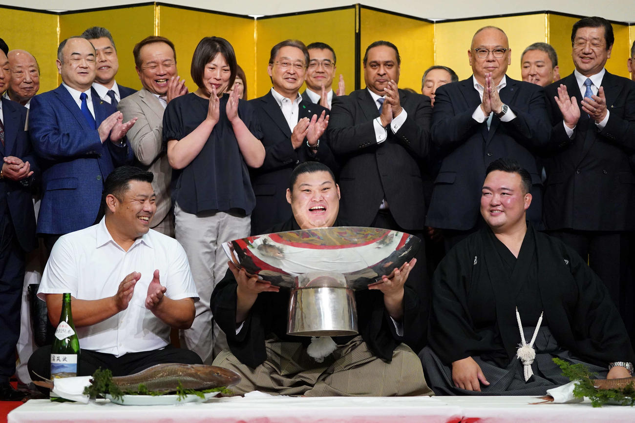 初優勝を飾った大の里は銀杯を手に満面の笑顔を見せる。手前右は師匠の二所ノ関親方、同左は父の中村知幸さん（撮影・小沢裕）