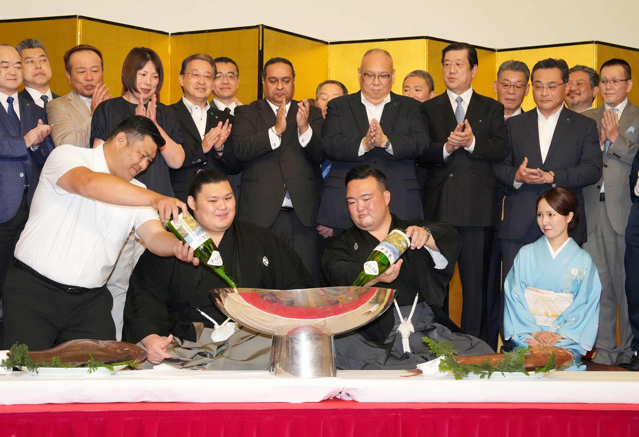 初優勝を飾った大の里（左から2人目）は、父知幸さん（左）、師匠の二所ノ関親方からお酒を注いでもらう。右はおかみさん（撮影・小沢裕）