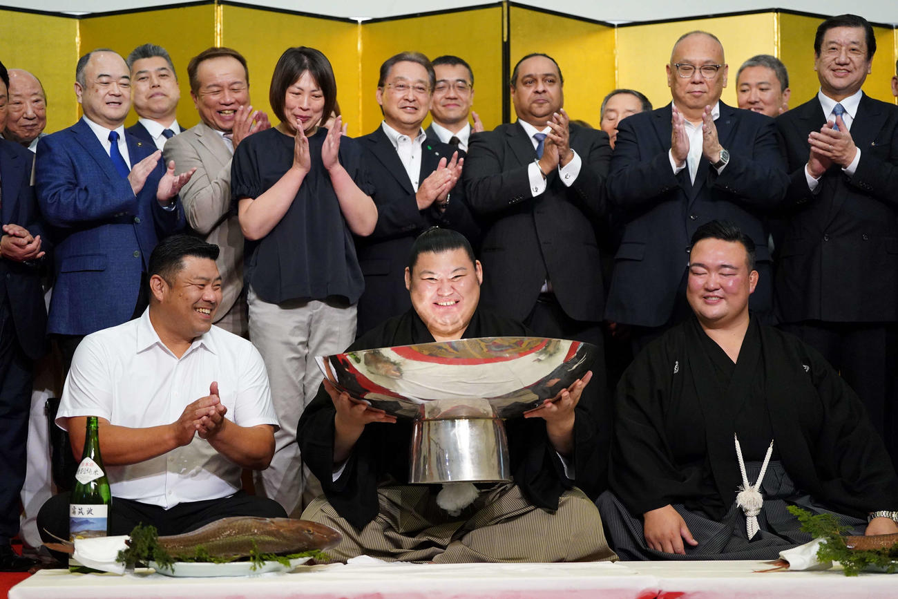 初優勝を飾った大の里（中央）は銀杯を手に満面の笑顔を見せる。右は師匠の二所ノ関親方（撮影・小沢裕）