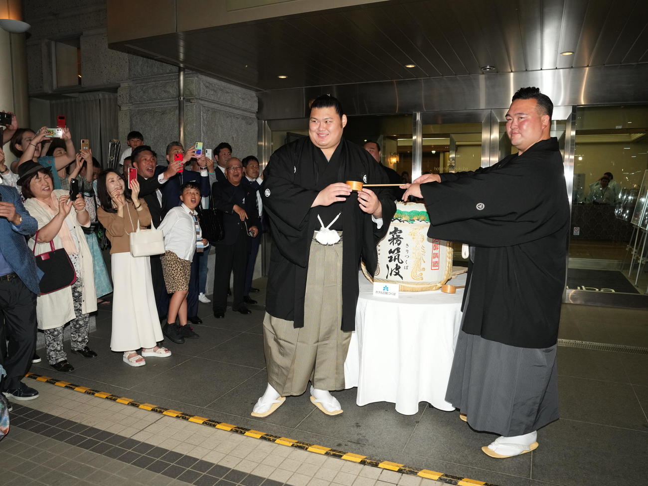 大相撲夏場所千秋楽、初優勝した大の里（左）は師匠の二所ノ関親方から水を付けてもらう（撮影・小沢裕）