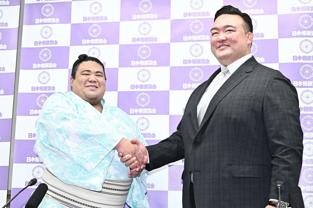 十両昇進が決まり握手を交わす嘉陽（左）と二所ノ関親方（撮影・滝沢徹郎）