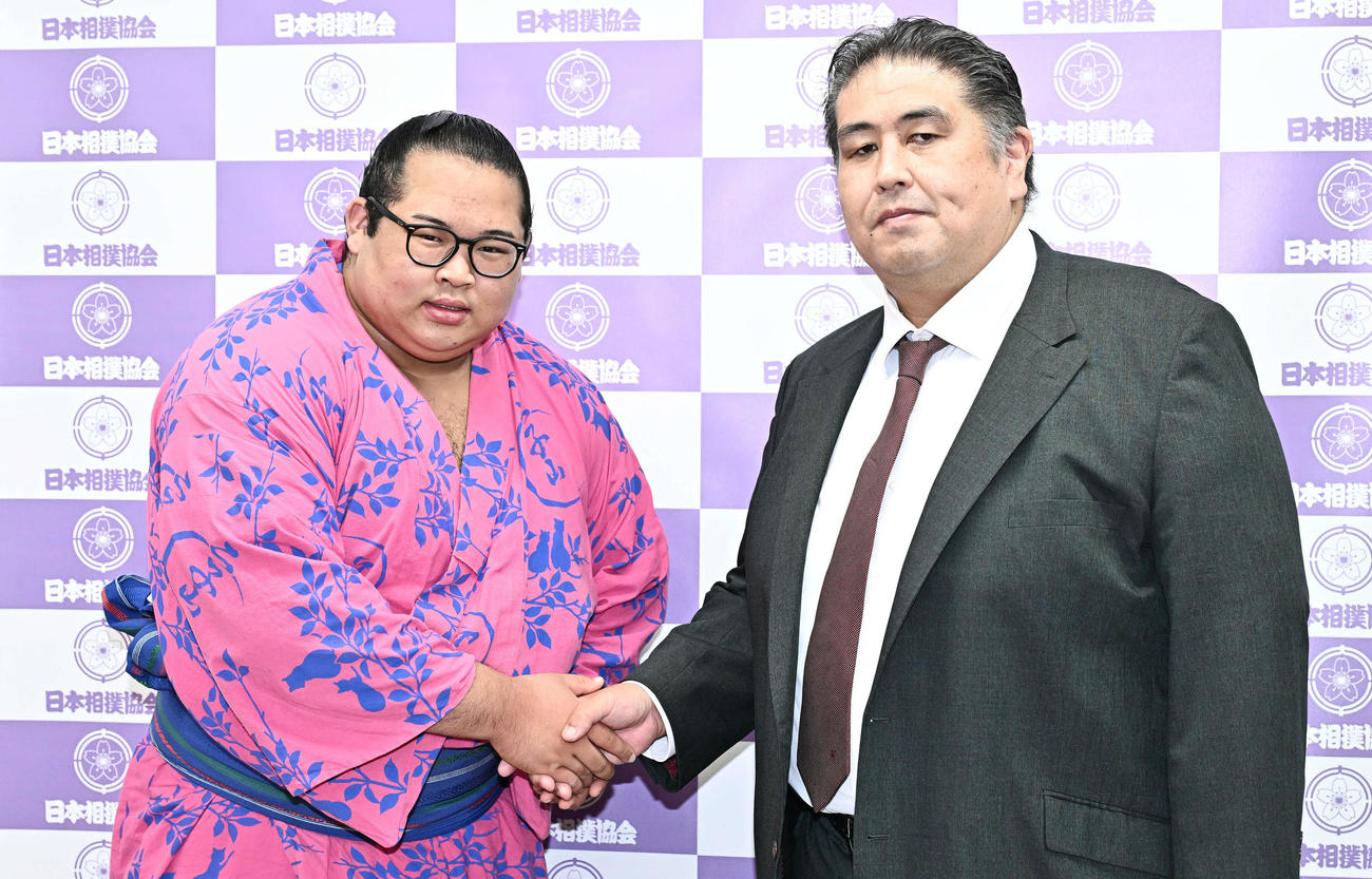 両昇進が決まり握手する生田目（左）と二子山親方（撮影・滝沢徹郎）
