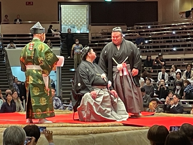 断髪式で埼玉栄高の後輩にあたる大関貴景勝（右）にはさみを入れられ、会話を交わす井筒親方