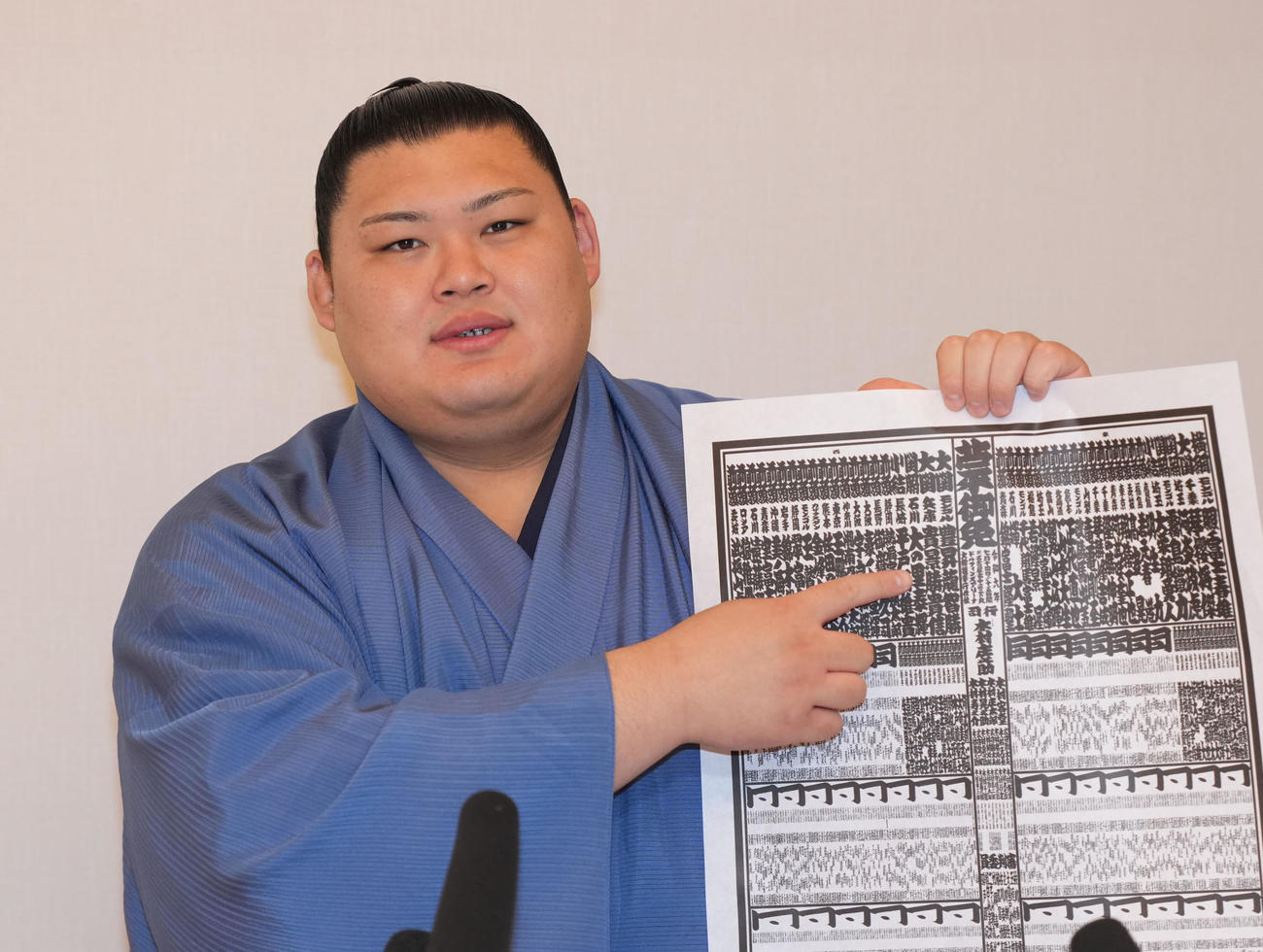 番付表を手に自身の名前を指さし撮影に応じる大の里（撮影・森本幸一）