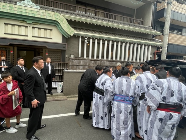 故岩友親方の棺を運び出す若い衆と、それを見守る師匠の春日野親方（左）