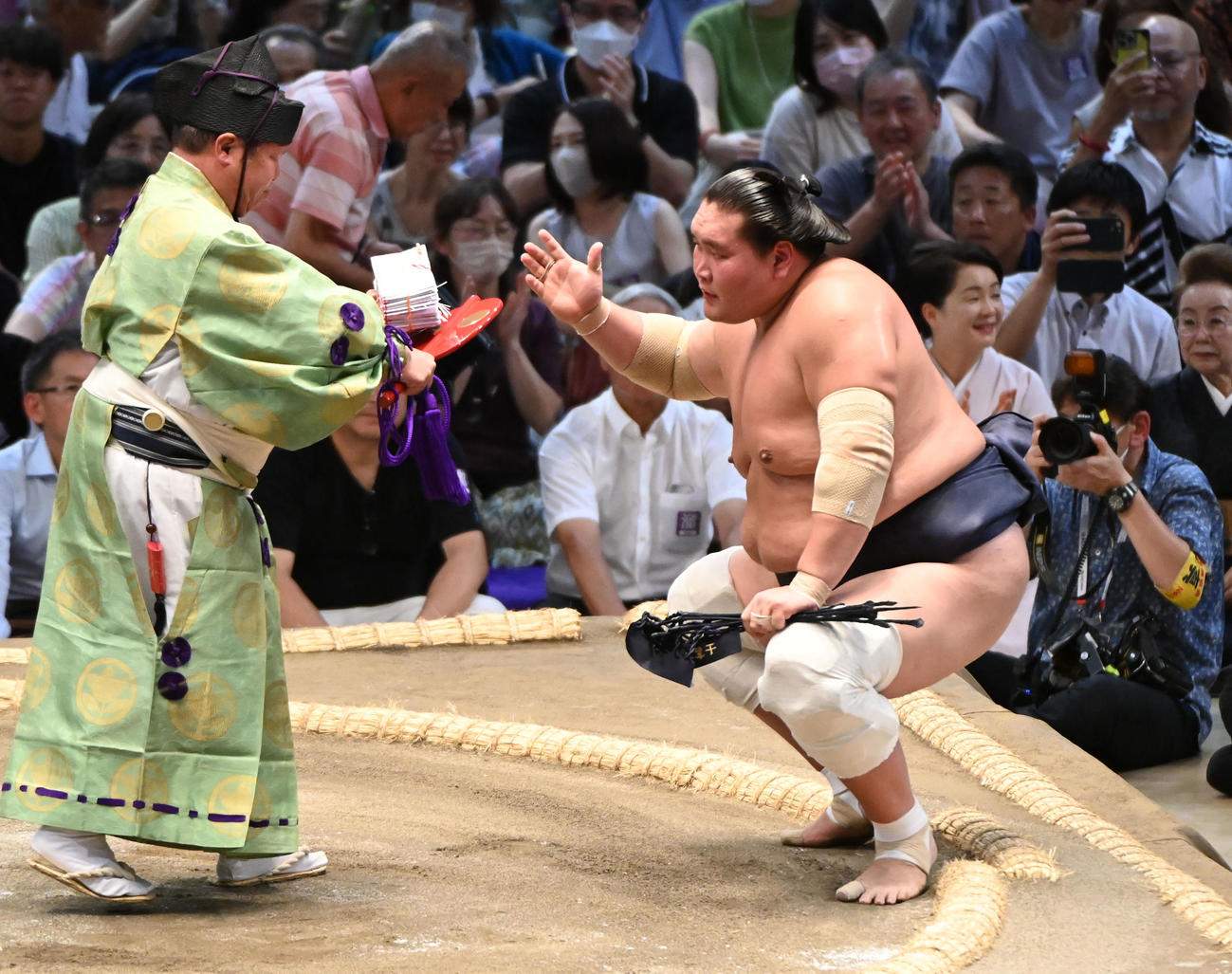 御嶽海を破り懸賞を受け取る照ノ富士（右）（撮影・森本幸一）